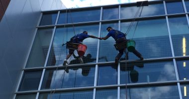 Two workers cleaning the exterior windows